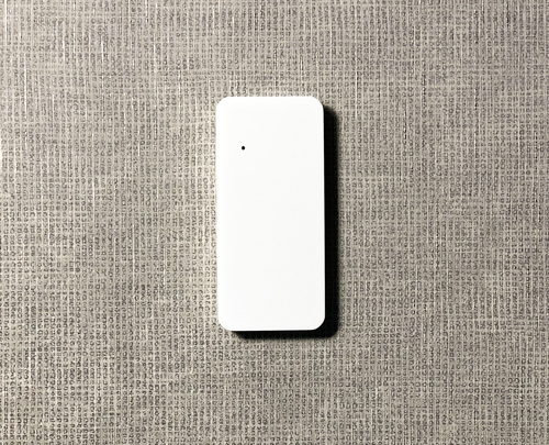 Белый считыватель AXI1 на бежевом фоне в интерьере